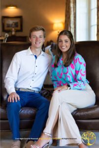 Casal jovem sorridente sentado em poltronas de couro, representando a harmonia e o consenso necessários para o processo de mudança de regime de bens.